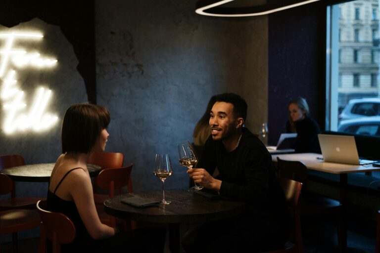 Turismo para casal na capital paulista: romance, gastronomia e experiências únicas Homem e mulher conversando em um restaurante moderno com vinho